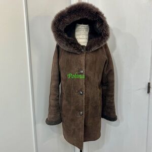 Brown medium length shearling lambskin coat. Hood is trimmed with real fox fur